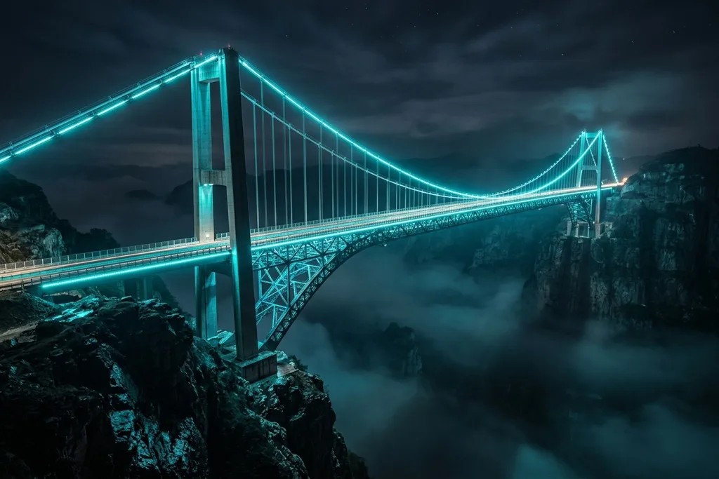 Massive steel and glass suspension bridge at night with cyan LED lighting connecting two dark cliffsides representing the question of whether immersive web experiences are essential infrastructure or optional luxury