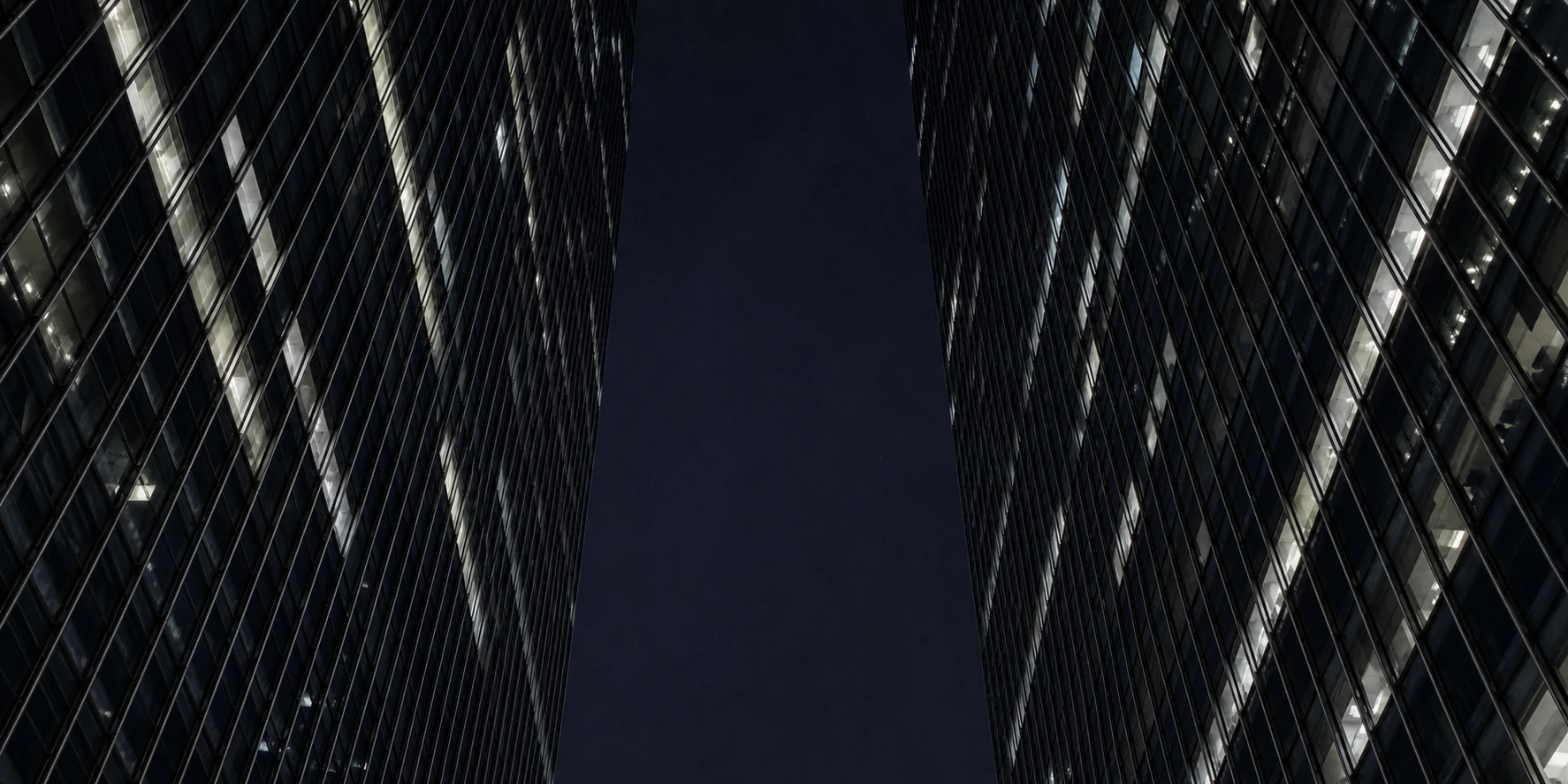 Enterprise AEO retainer ROI for brands, skyscraper canyon at deep night with selective floor illumination